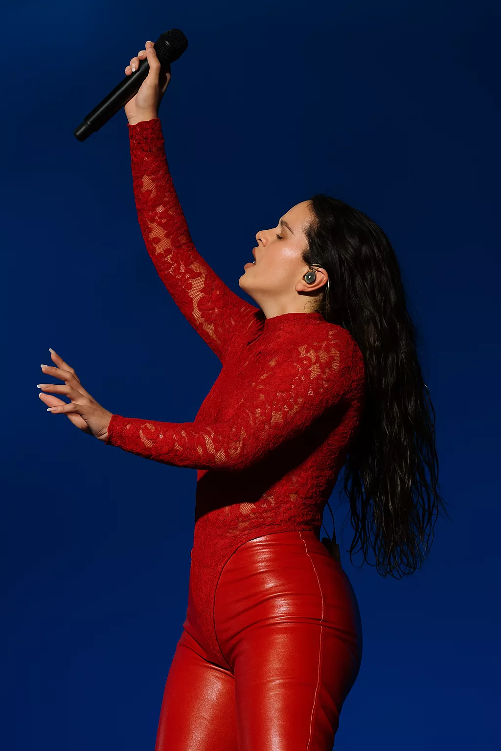 Scène immersive avec éclairages lumineux évoquant un concert de Rosalía au Lux Tour 2026 à Paris, ambiance énergique et couleurs intenses sans présence de visage.